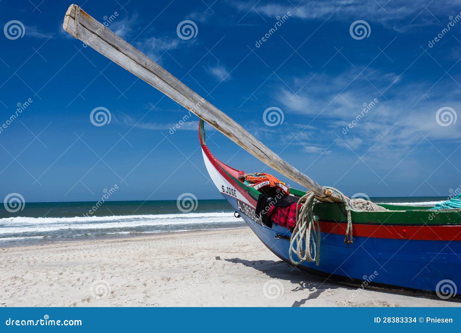 Prow of colorful Portuguese moliceiros fishing boat with oar lifting 