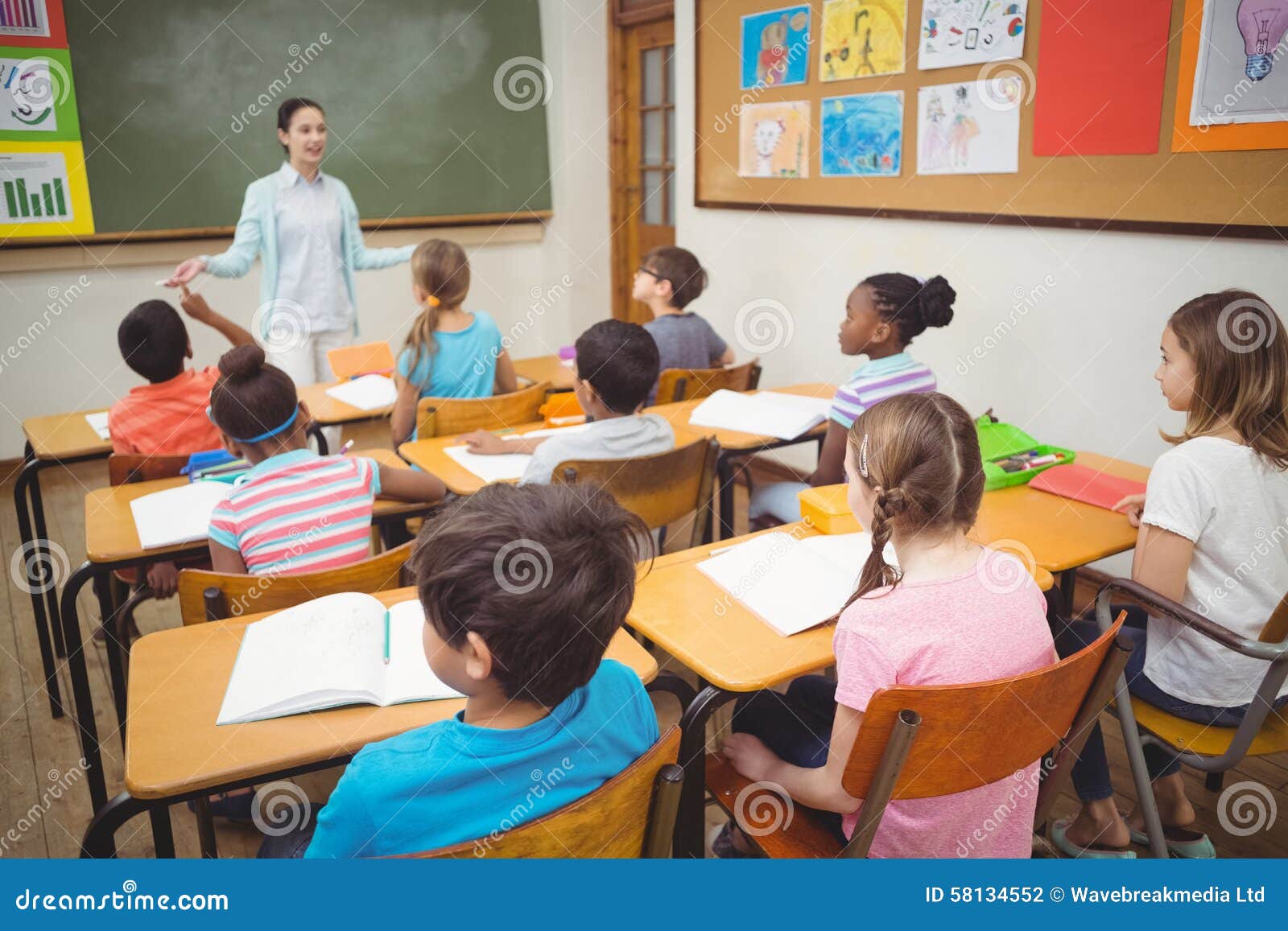 pupils listening to teacher class elementary school 58134552