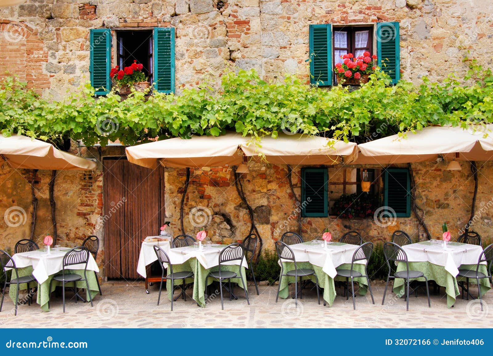 Cafe tables and chairs outside a quaint stone building in Tuscany 