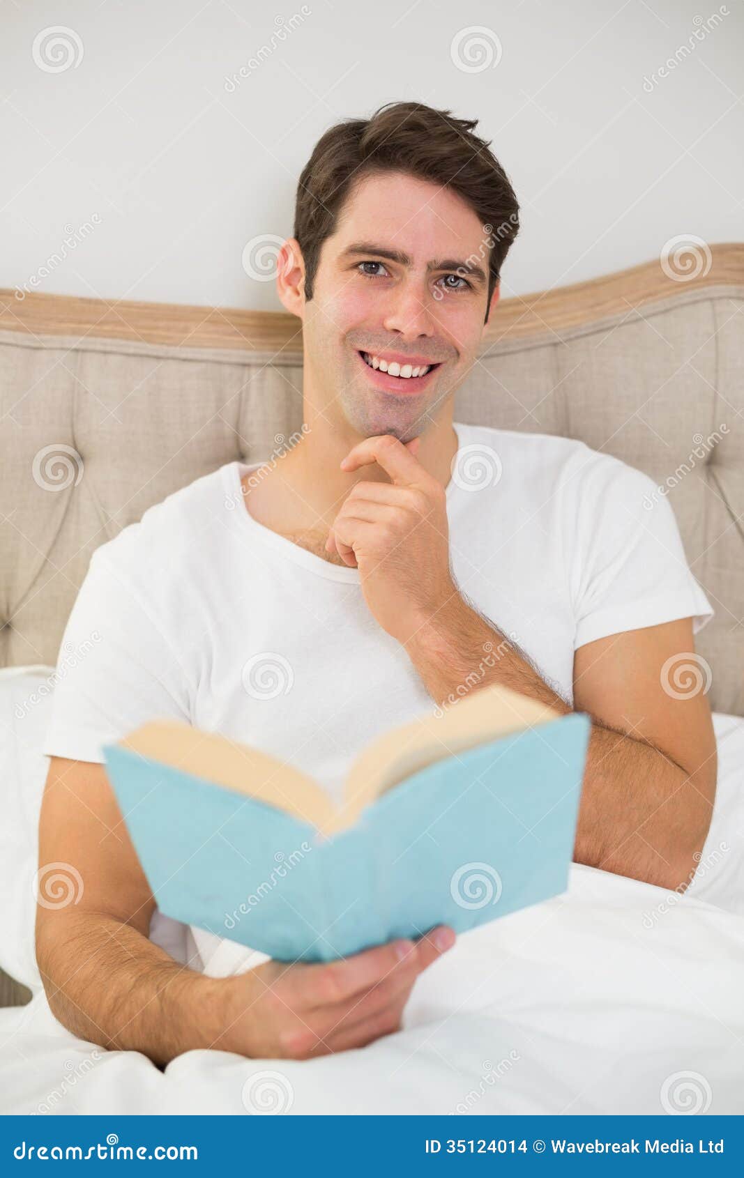 Retrato Do Livro De Leitura Relaxado Do Homem Novo Na Cama Foto De