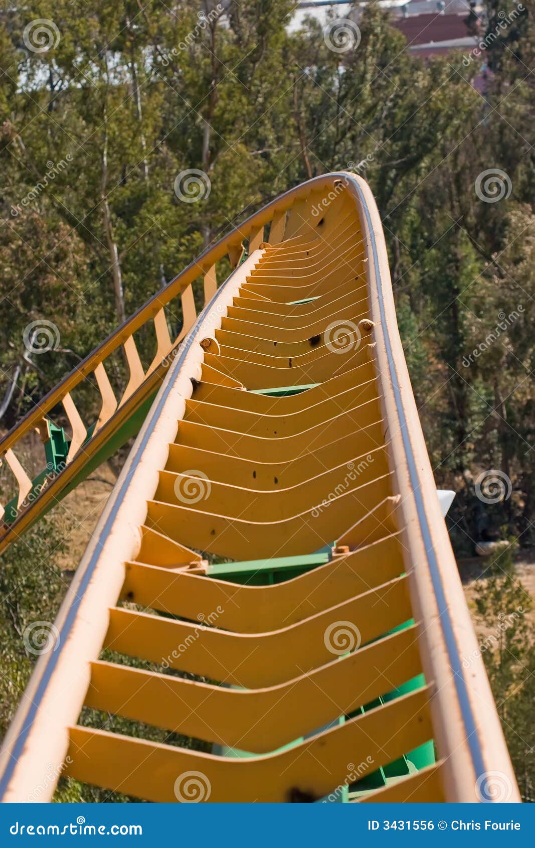 Close up of roller coaster track curving down.