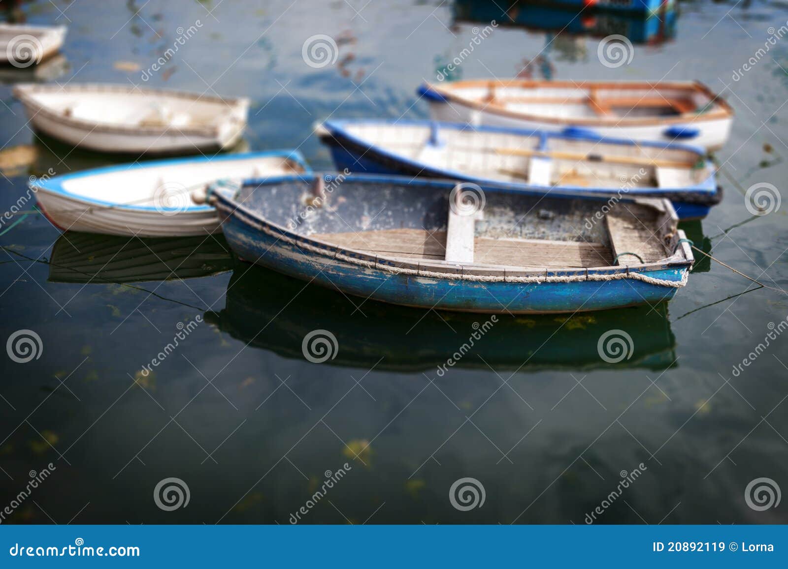 Rowing boats at anchor. Small fishing vessels on water.