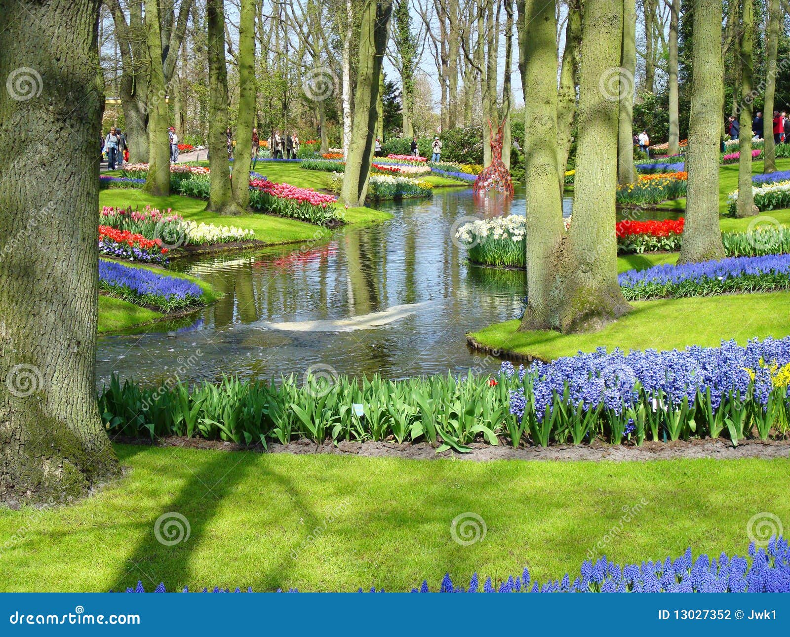 Scenic garden with colorful spring flowers and pond in dutch spring ...