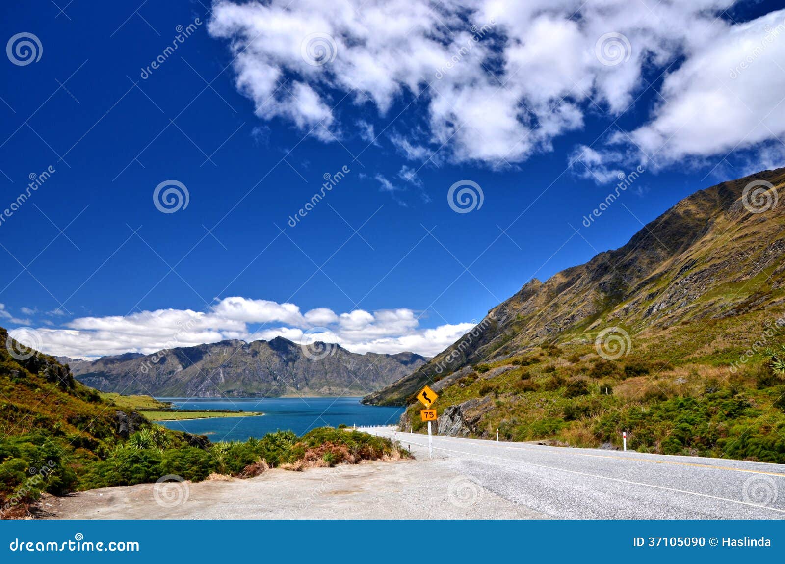 Scenic mountain road in new zealand with Lake Hawea in the background.