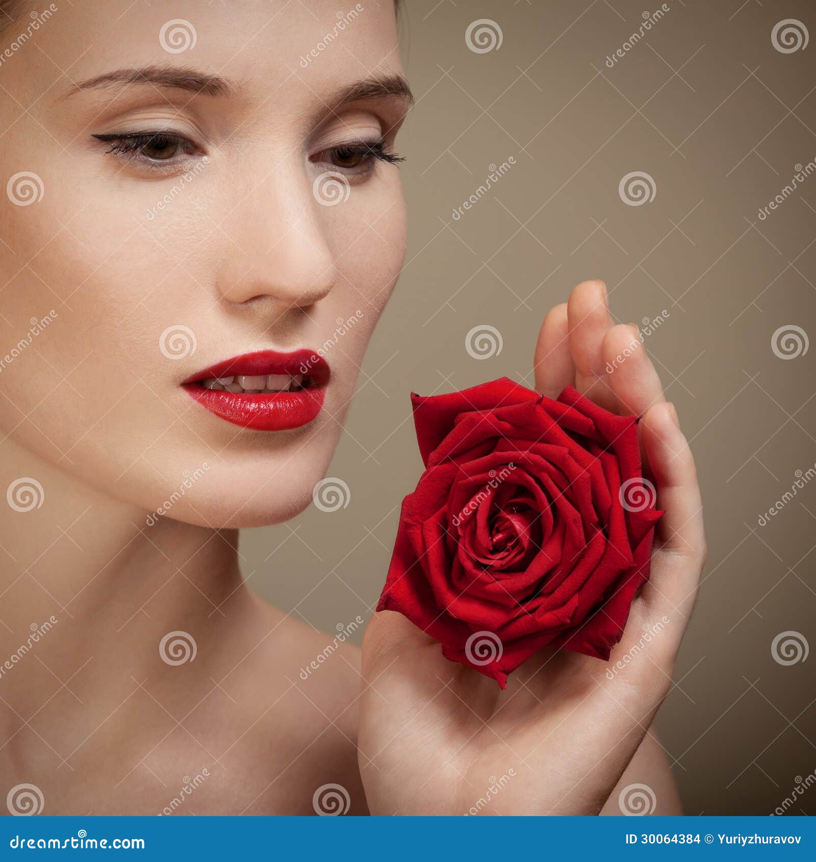 Schöne Frau, die in der Hand rote Rose hält Stockbilder