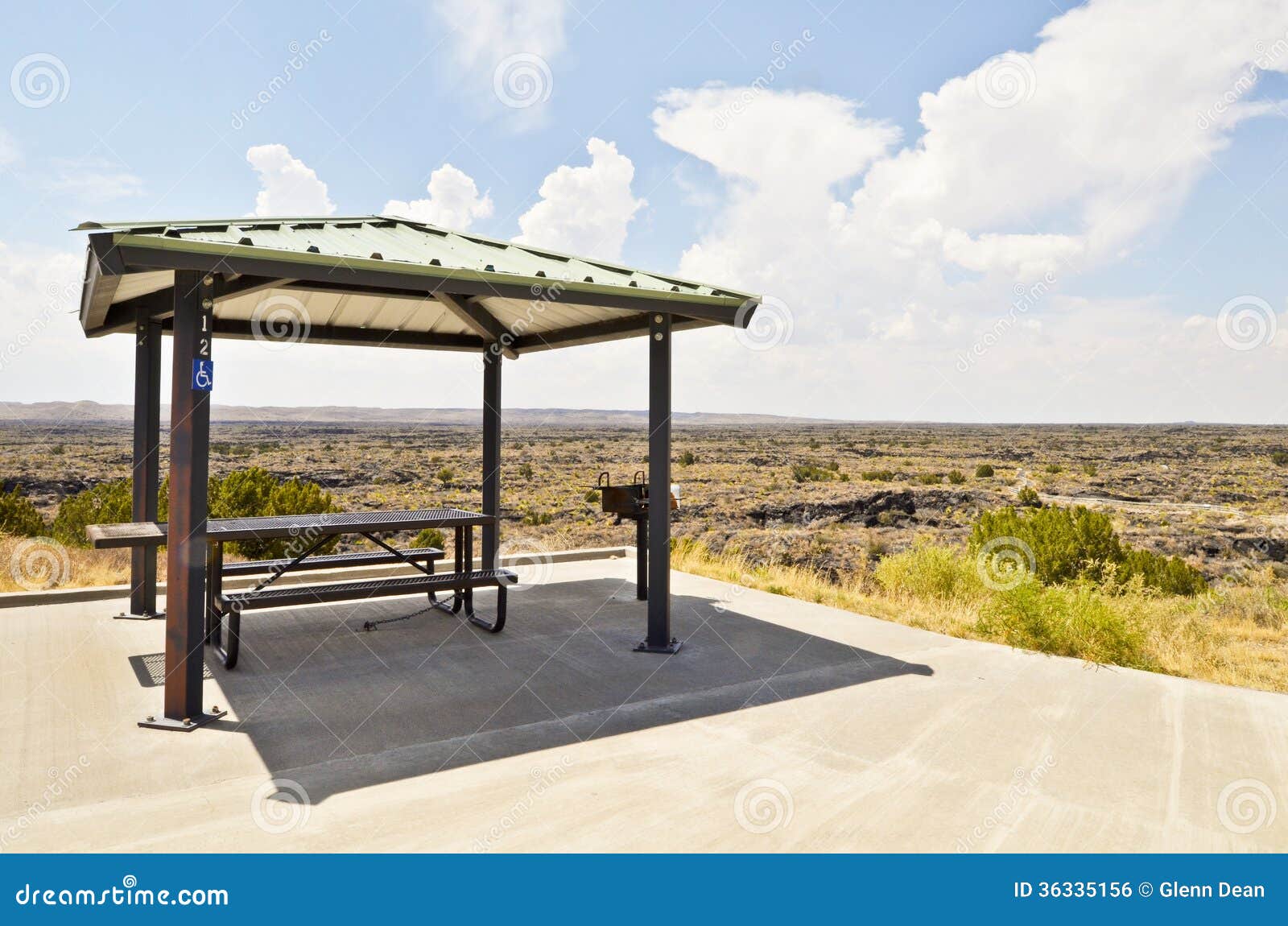 Covered picnic table providing shade in an open, barren desert. New 