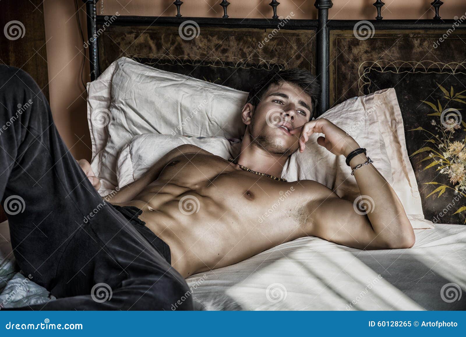 shirtless-sexy-male-model-lying-alone-his-bed-bedroom-looking-away-seductive-attitude-60128265.jpg