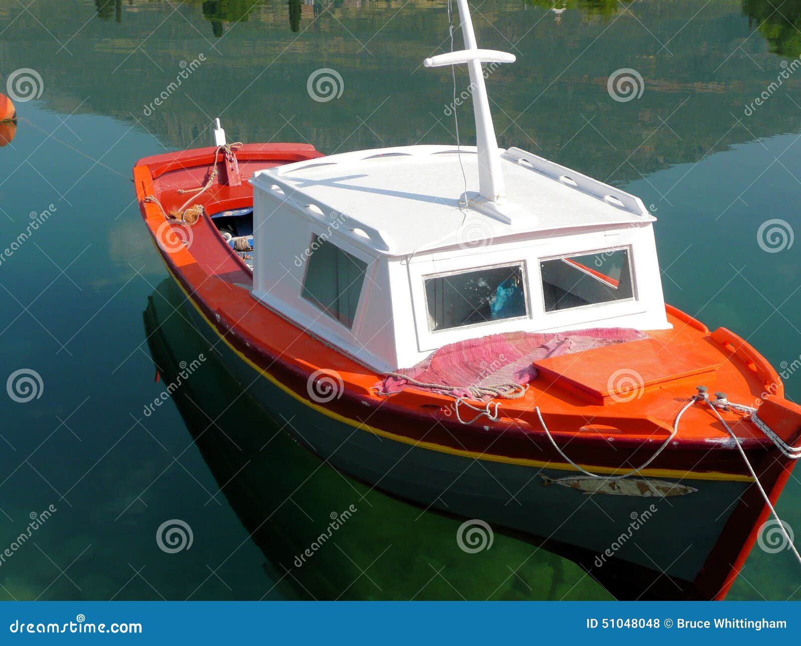 Small colorful half cabin wooden fishing boat, caique, Greece.