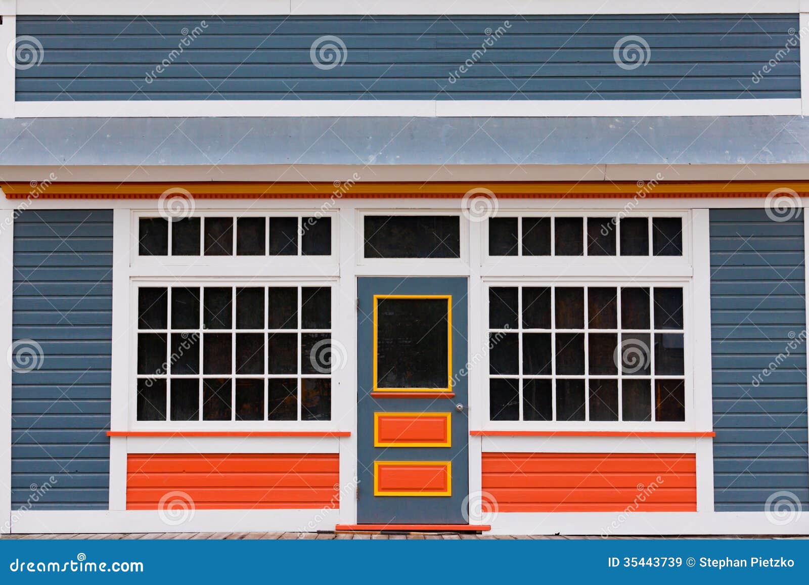  colorful wooden house with large cottage pane windows on either side