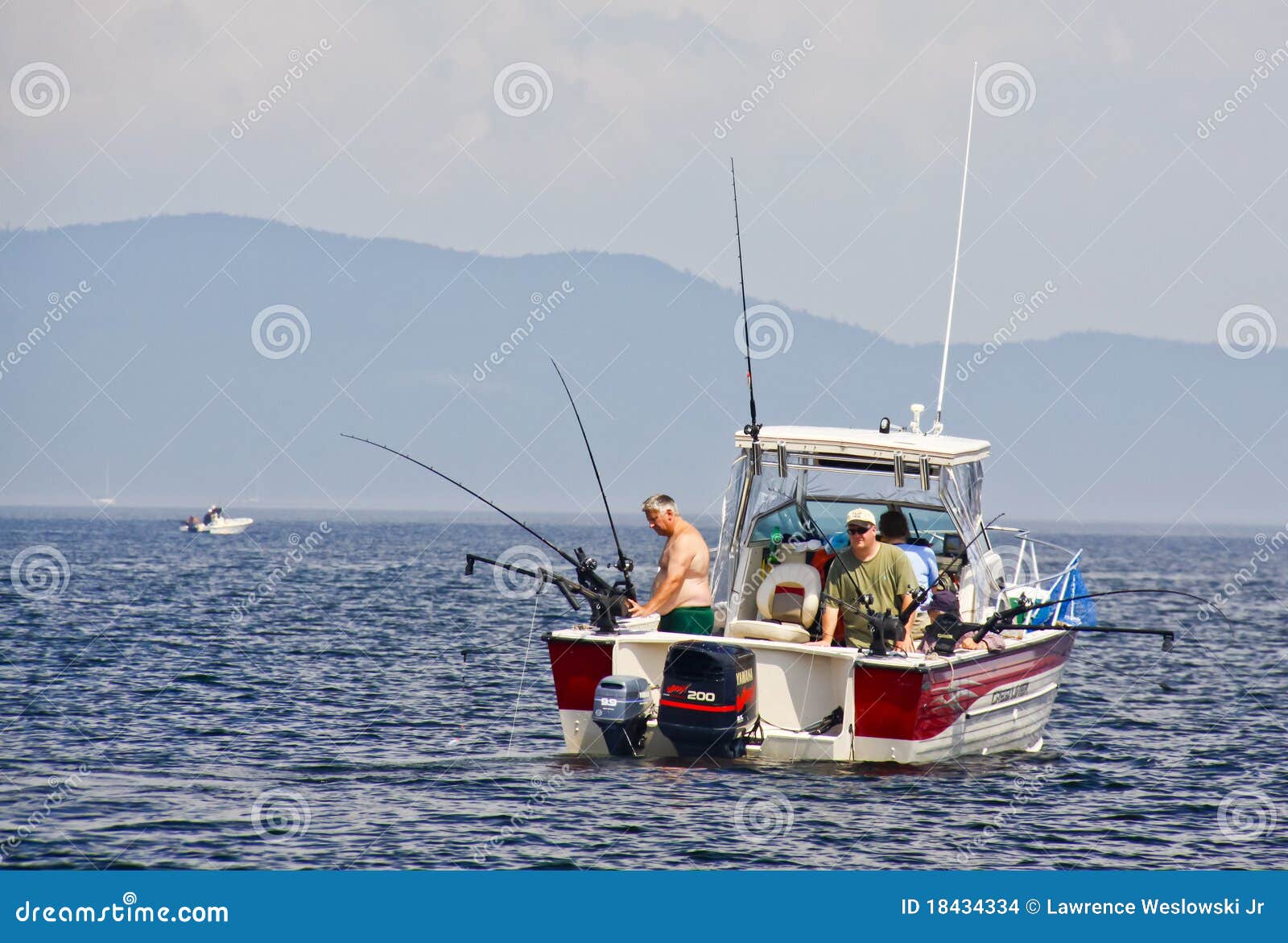 Fishermen on a recreational fishing boat looking for salmon and lake 