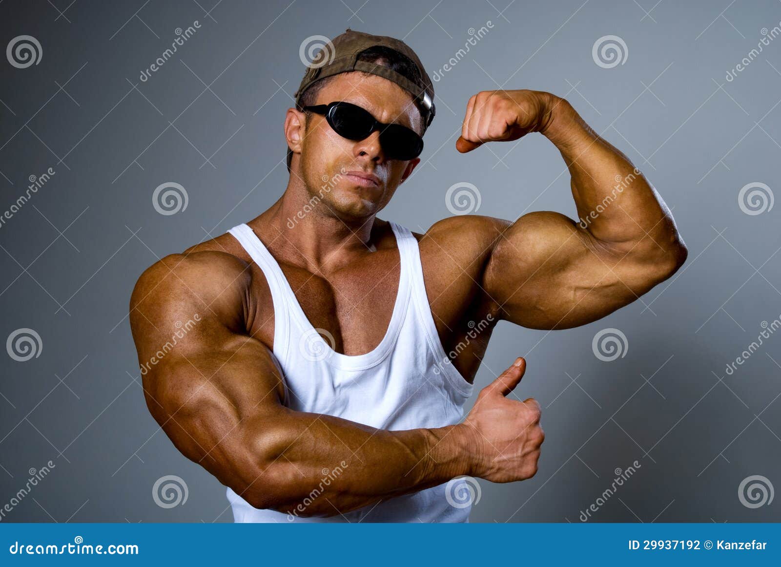 strong-man-sunglasses-shows-his-muscles-trained-body-gray-background-29937192.jpg