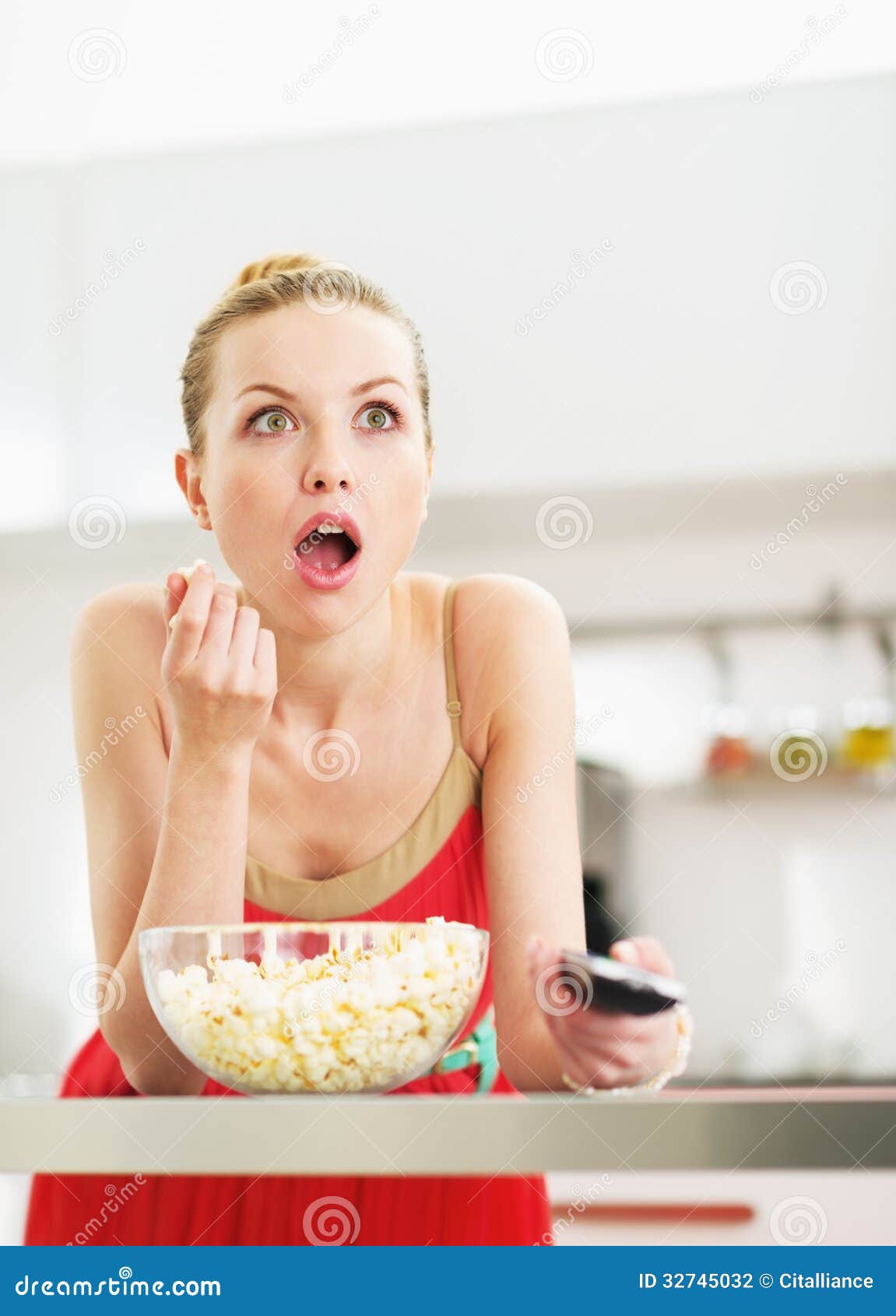 surprised-young-woman-eating-popcorn-wat