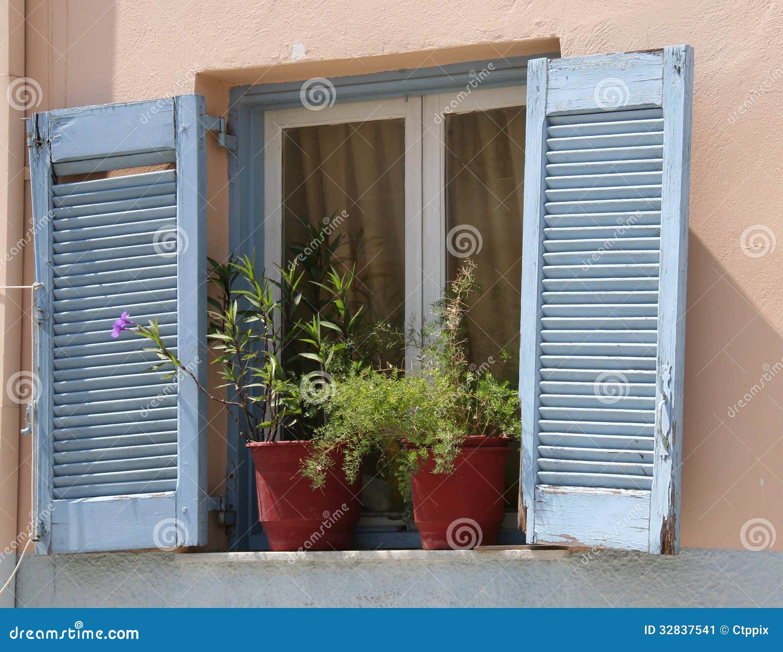 Traditional Greek Blue Window Shutters with white window frames and 