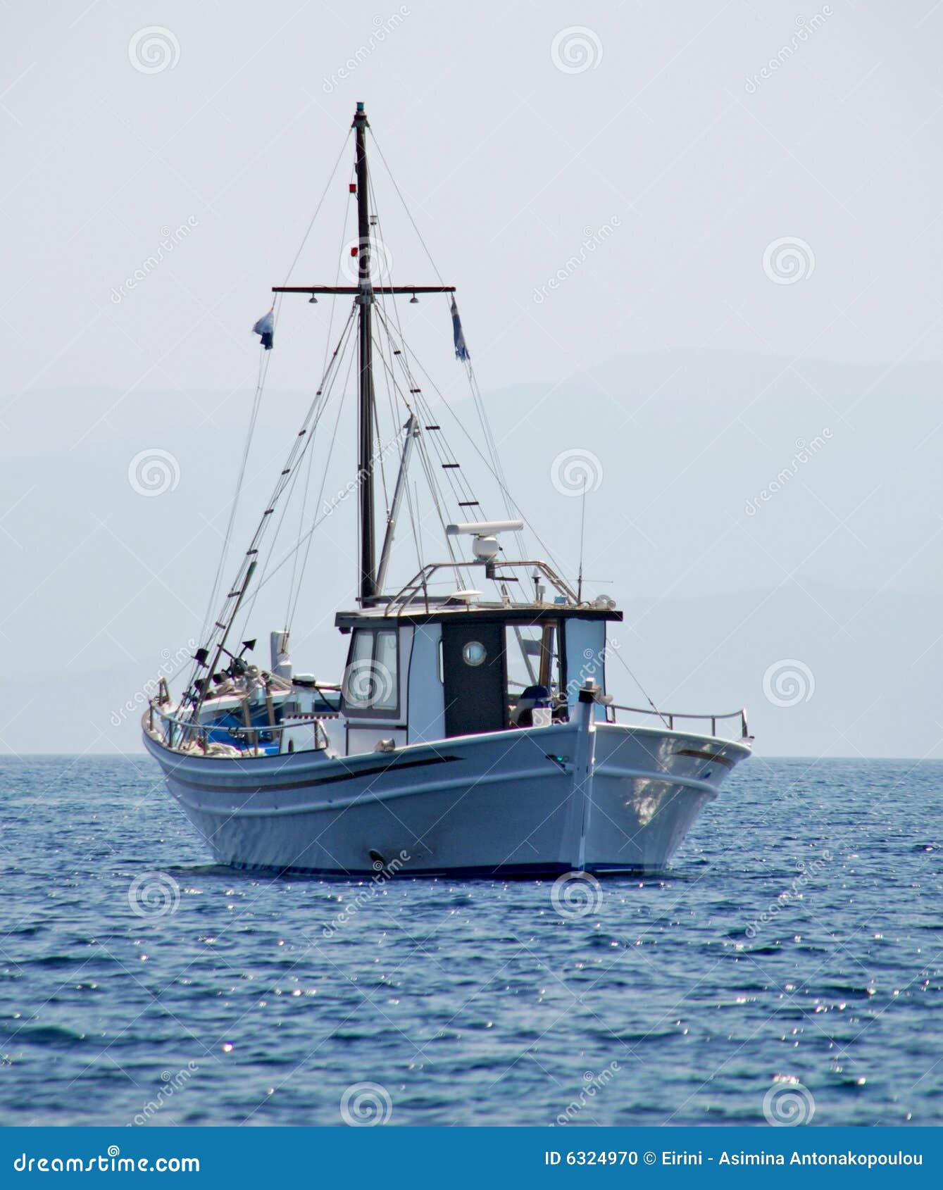 Traditional Greek fishing boat sailing in the Aegean sea, nearby the