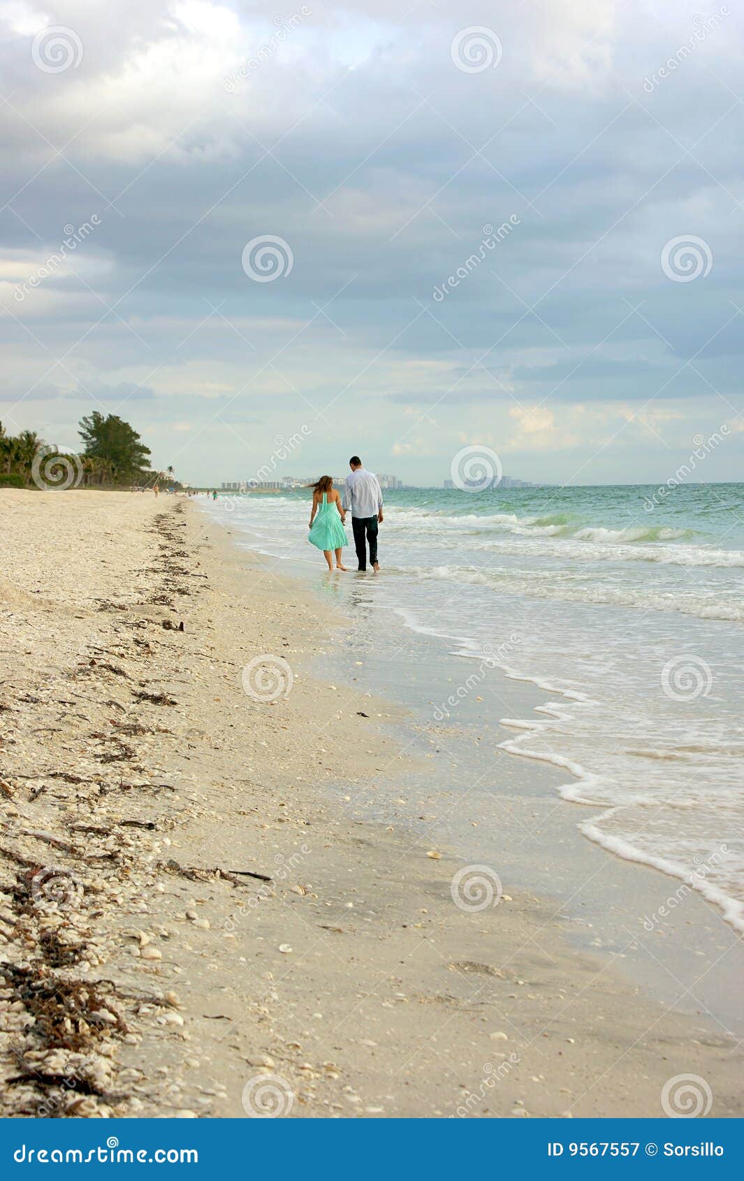 People Walking Away On The Beach