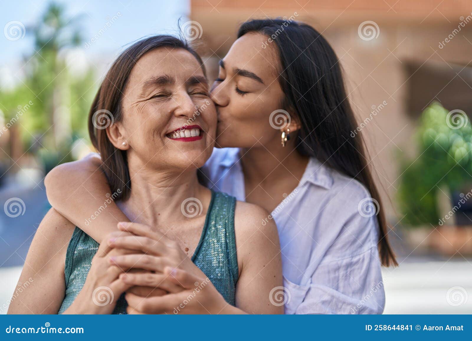 Two Women Mother And Daughter Hugging Each Other Kissing At Street