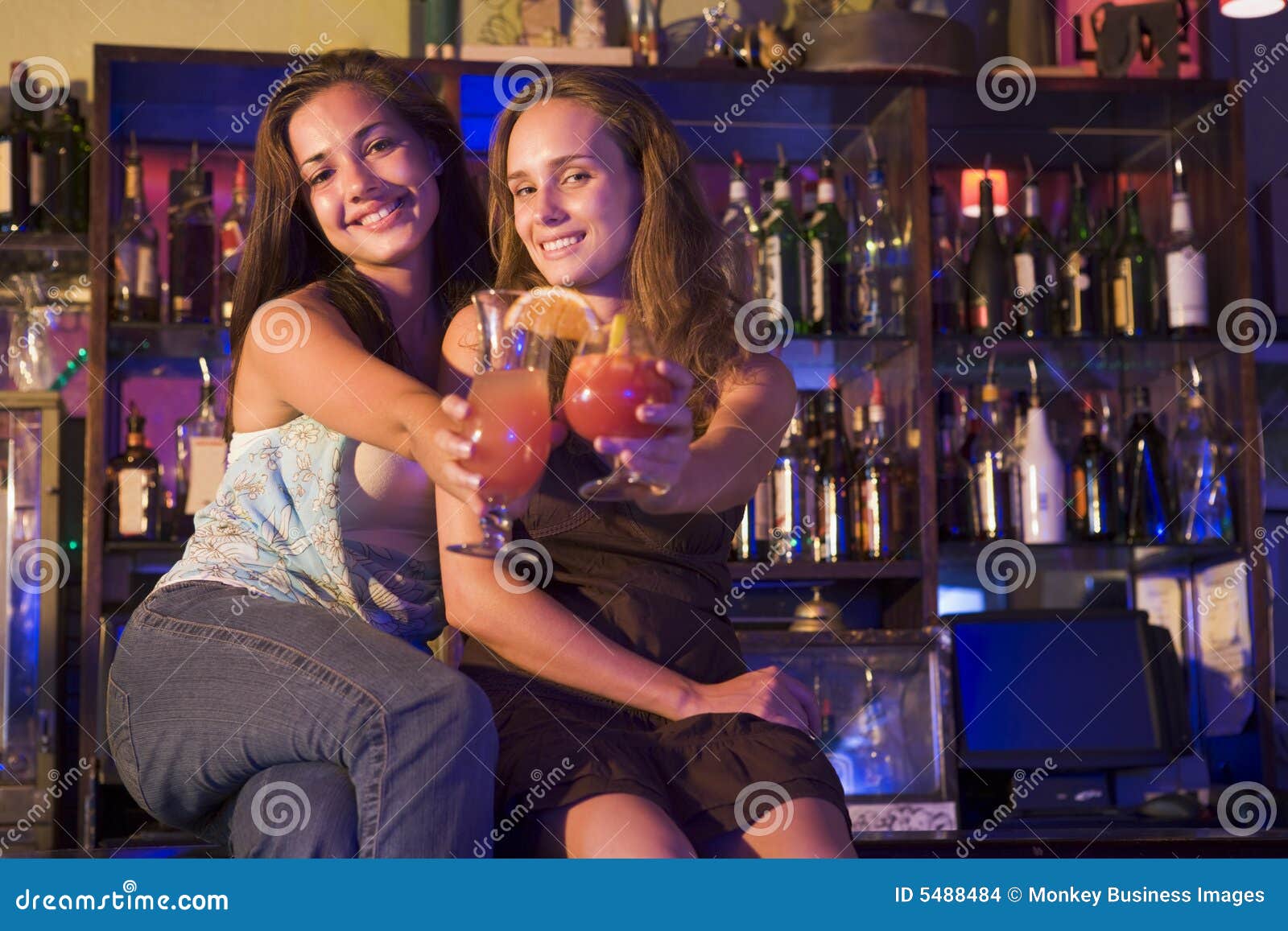 Two Young Women Sitting On A Bar Counter Toasting Stock Images Image 5488484