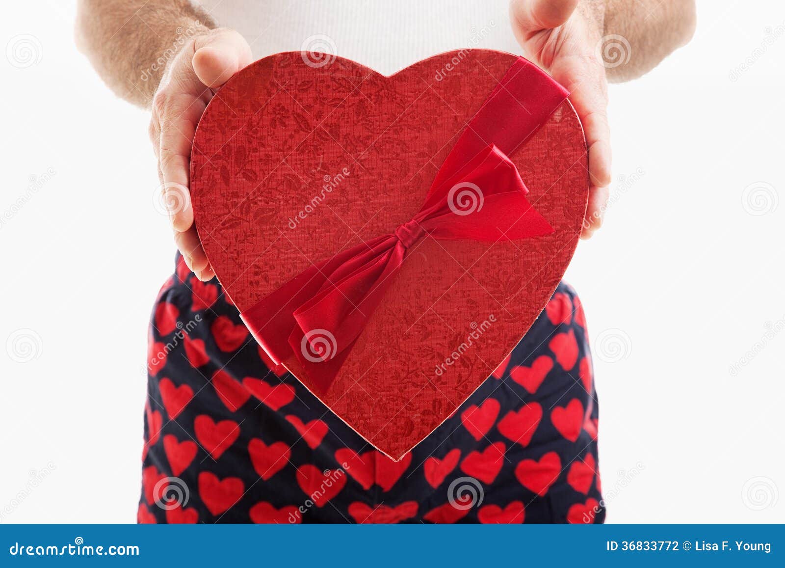 Man in hear underwear holding a big red Valentines Day heart filled ...