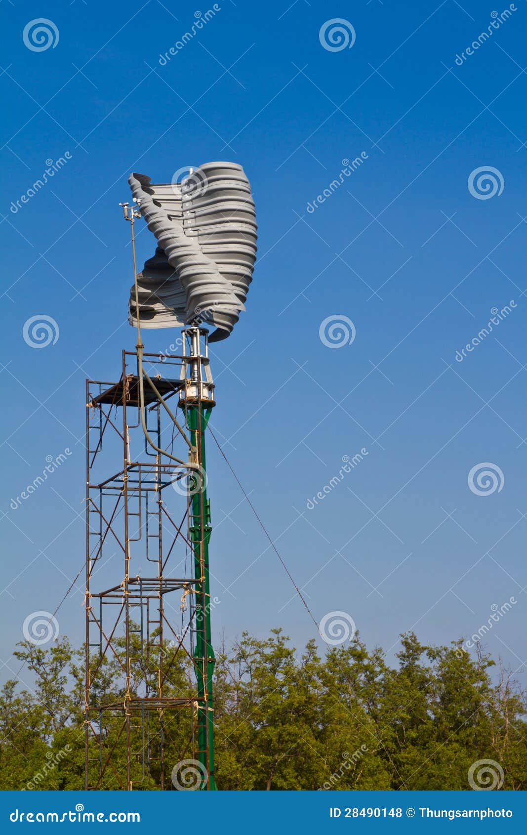 Vertical wind turbine under construction against blue sky.
