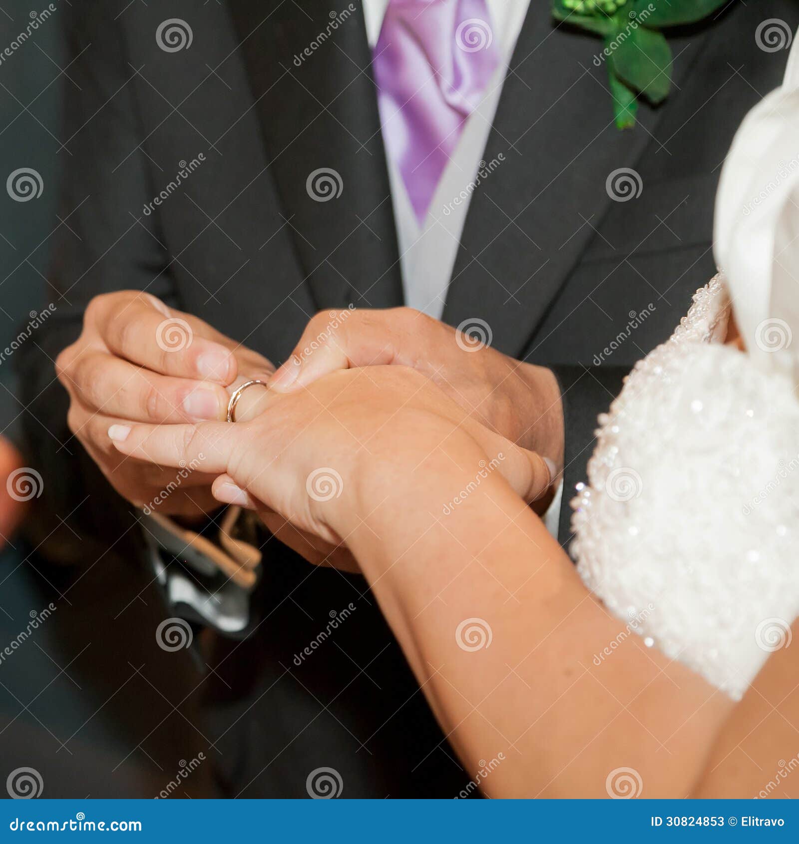 The groom puts the wedding ring to finger of the bride.