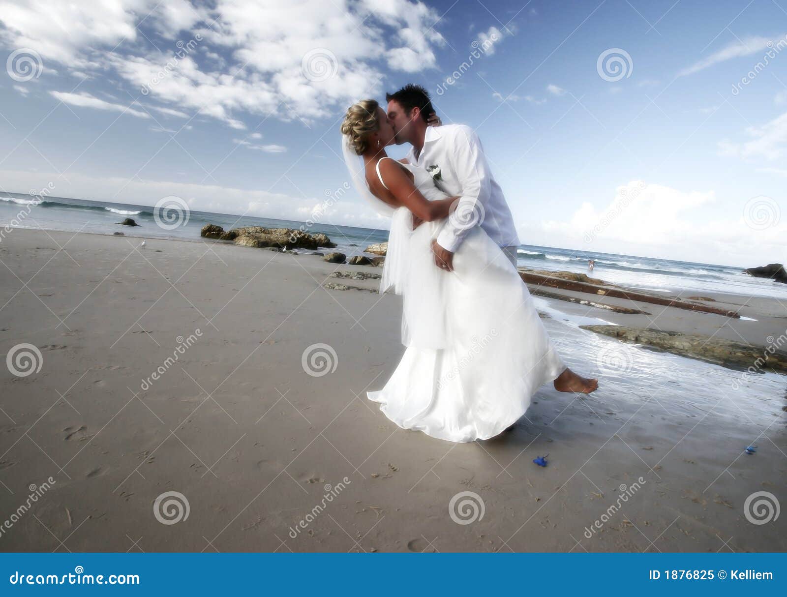 Wedding kiss as husband and wife shot on the beach of a resort 