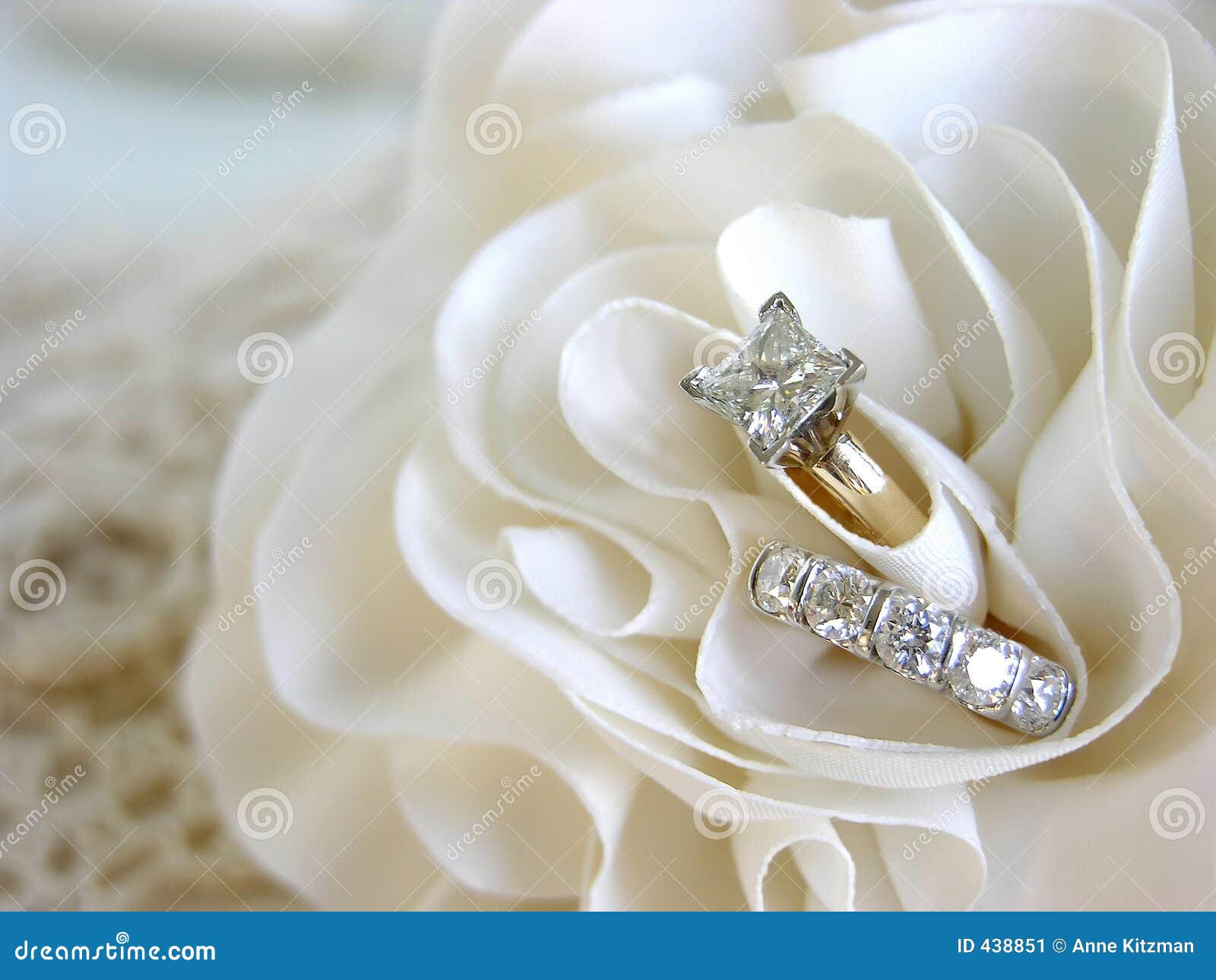Diamond wedding rings in the folds of the bride's dress.