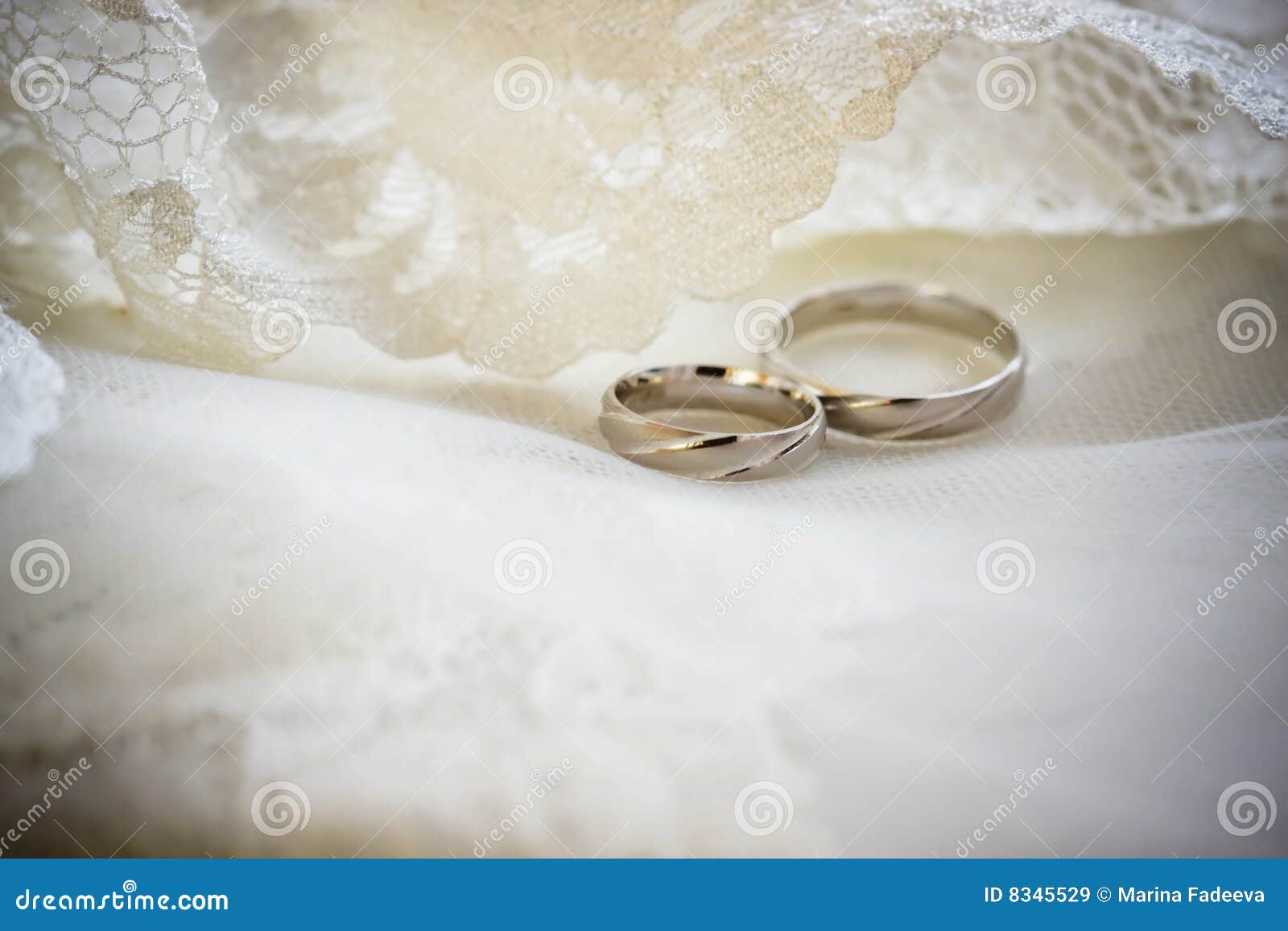 Wedding rings of white gold on a lace background.