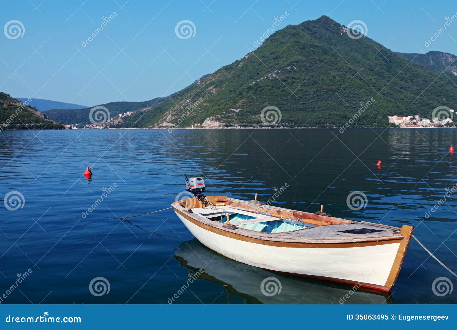 White wooden fishing boat floats moored in Perast town, Adriatic sea 