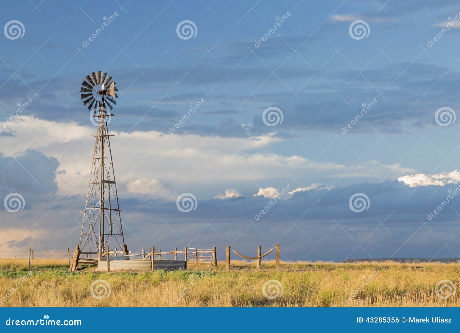 Windmill with a pump and cattle water tank in shortgrass prairie 