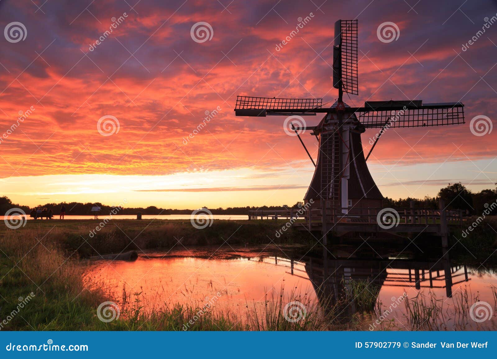 Traditional, Dutch windmill at a pond during a colorful, summer sunset 