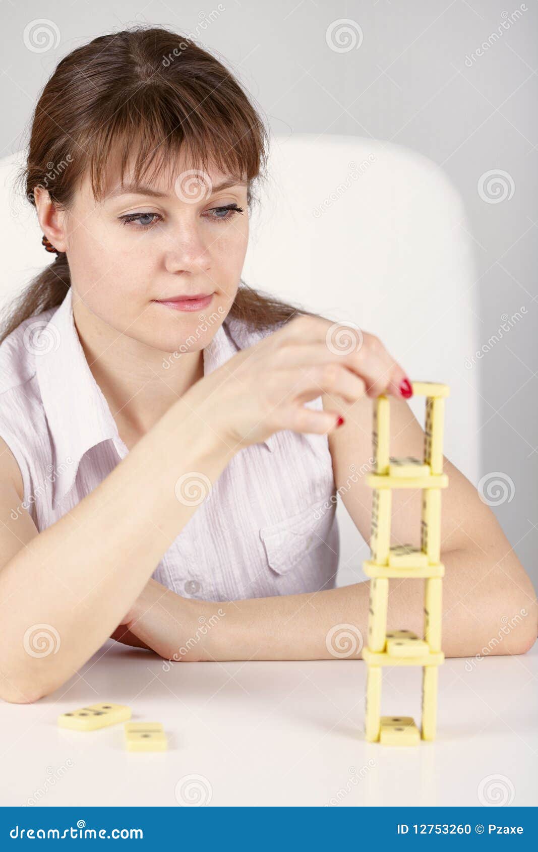 Builds Precarious Tower Of Dominoes Builds Precarious Tower Of Dominoes Stock Photo