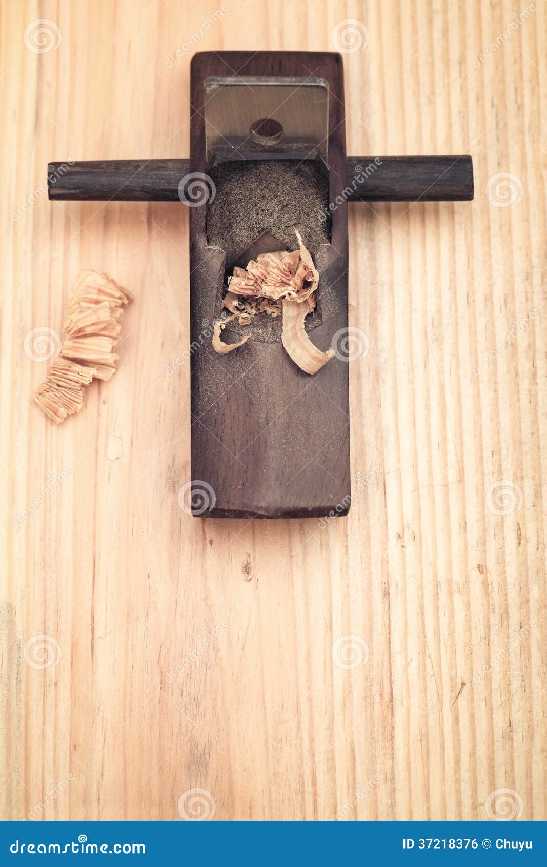 Small wood planer and shavings closeup on wooden background.