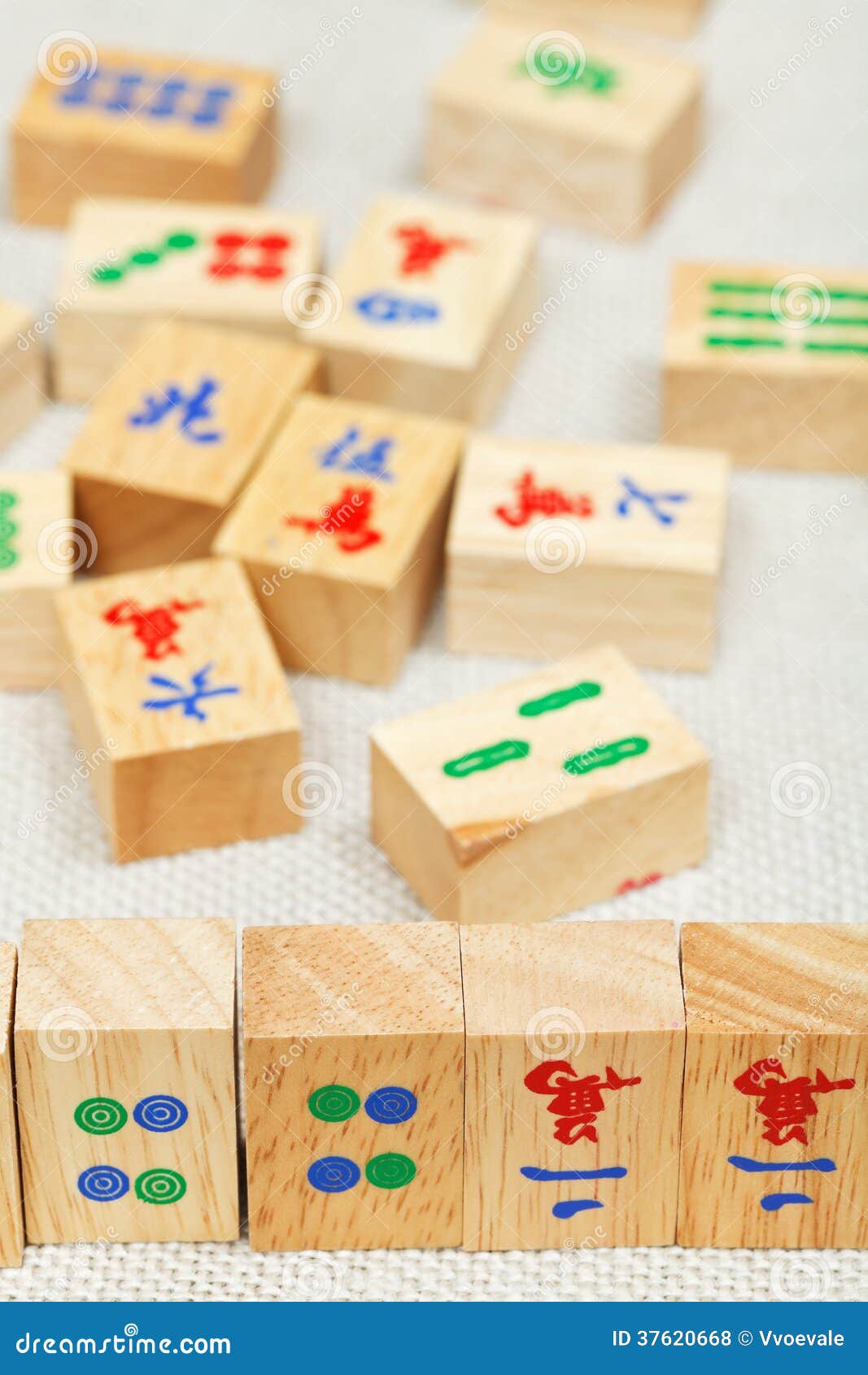 Wood tiles closeup in mahjong game during playing on textile table.