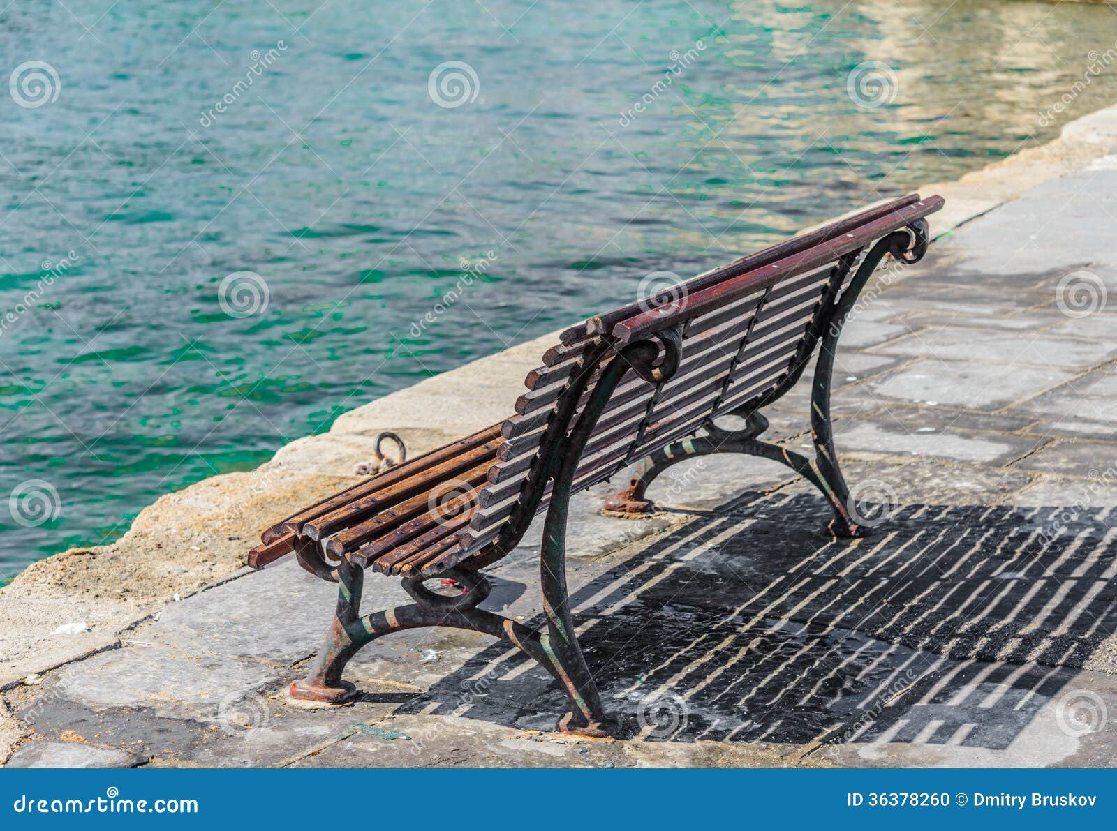 Old wooden bench on the promenade sea bay.