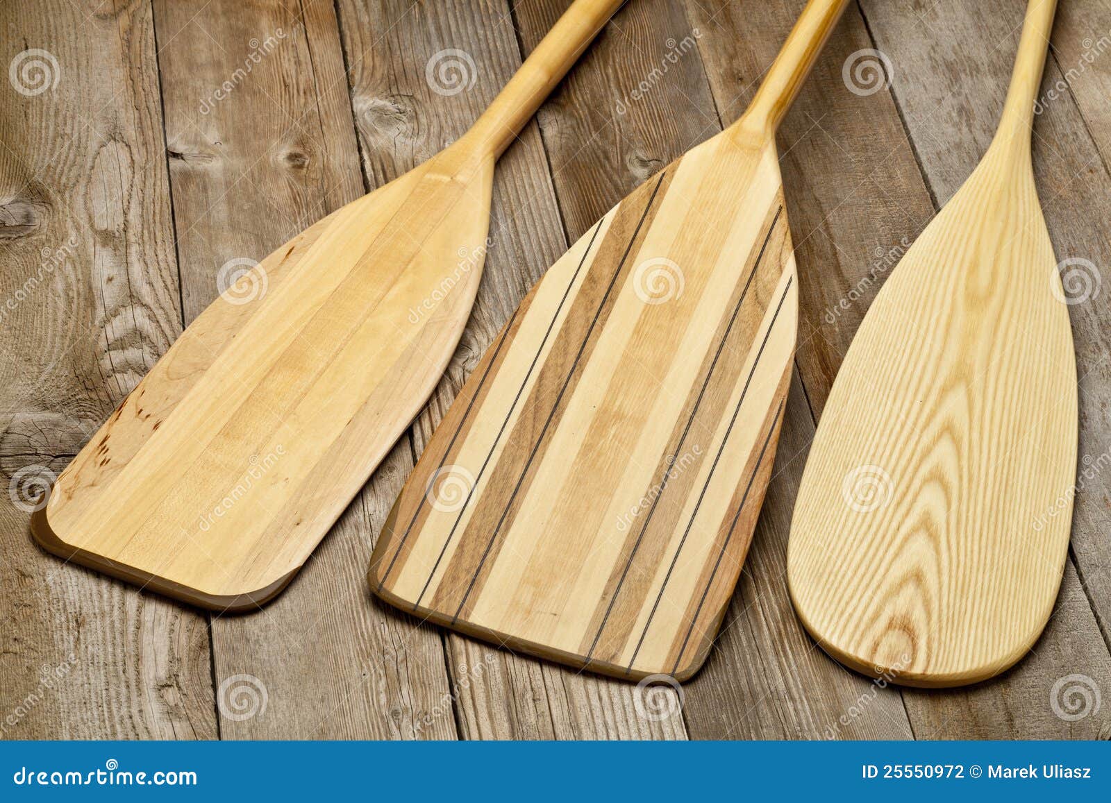  wooden canoe paddles of different shape against grunge wood surface