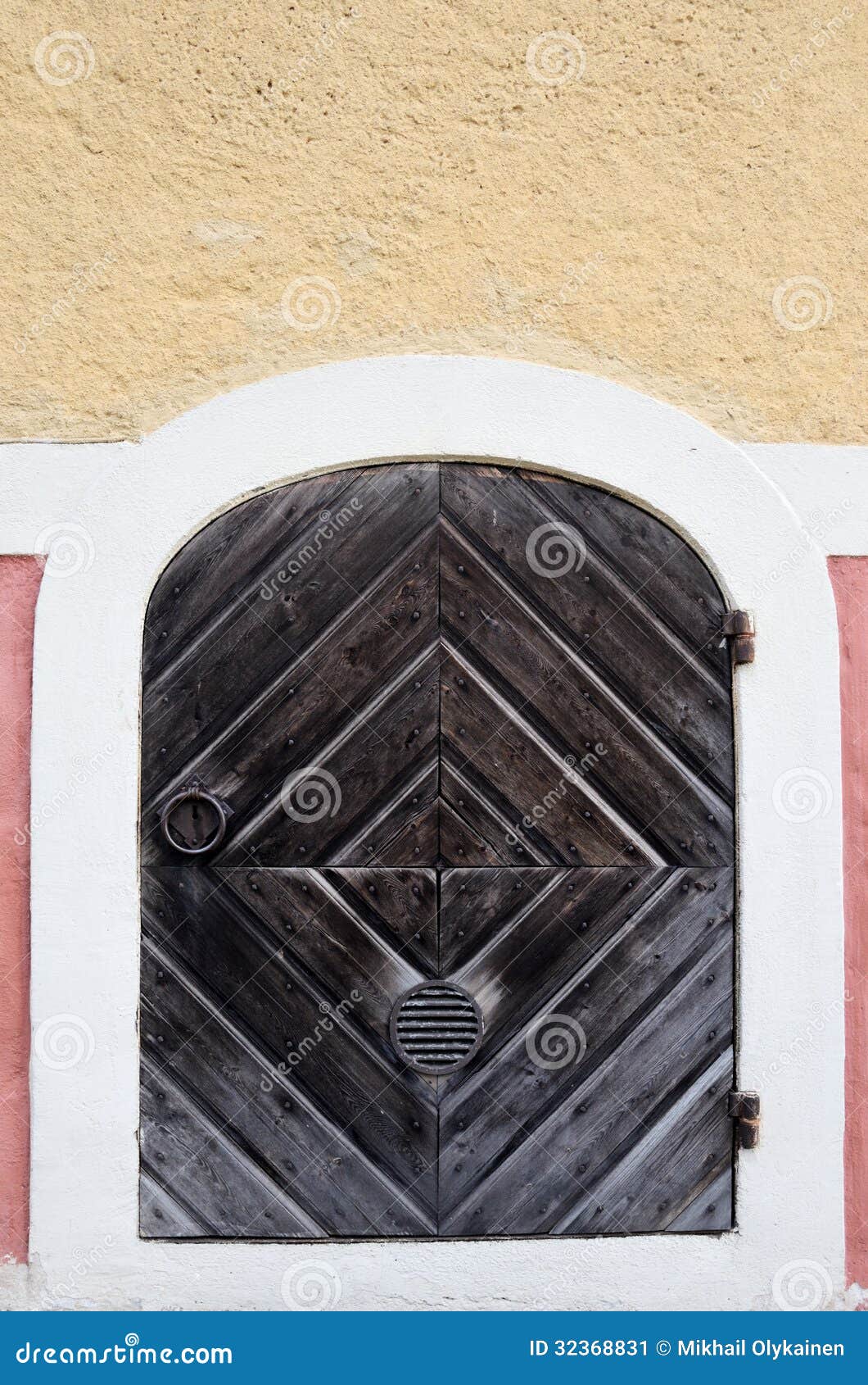 Wooden old door with wrought-iron hinges and ring.