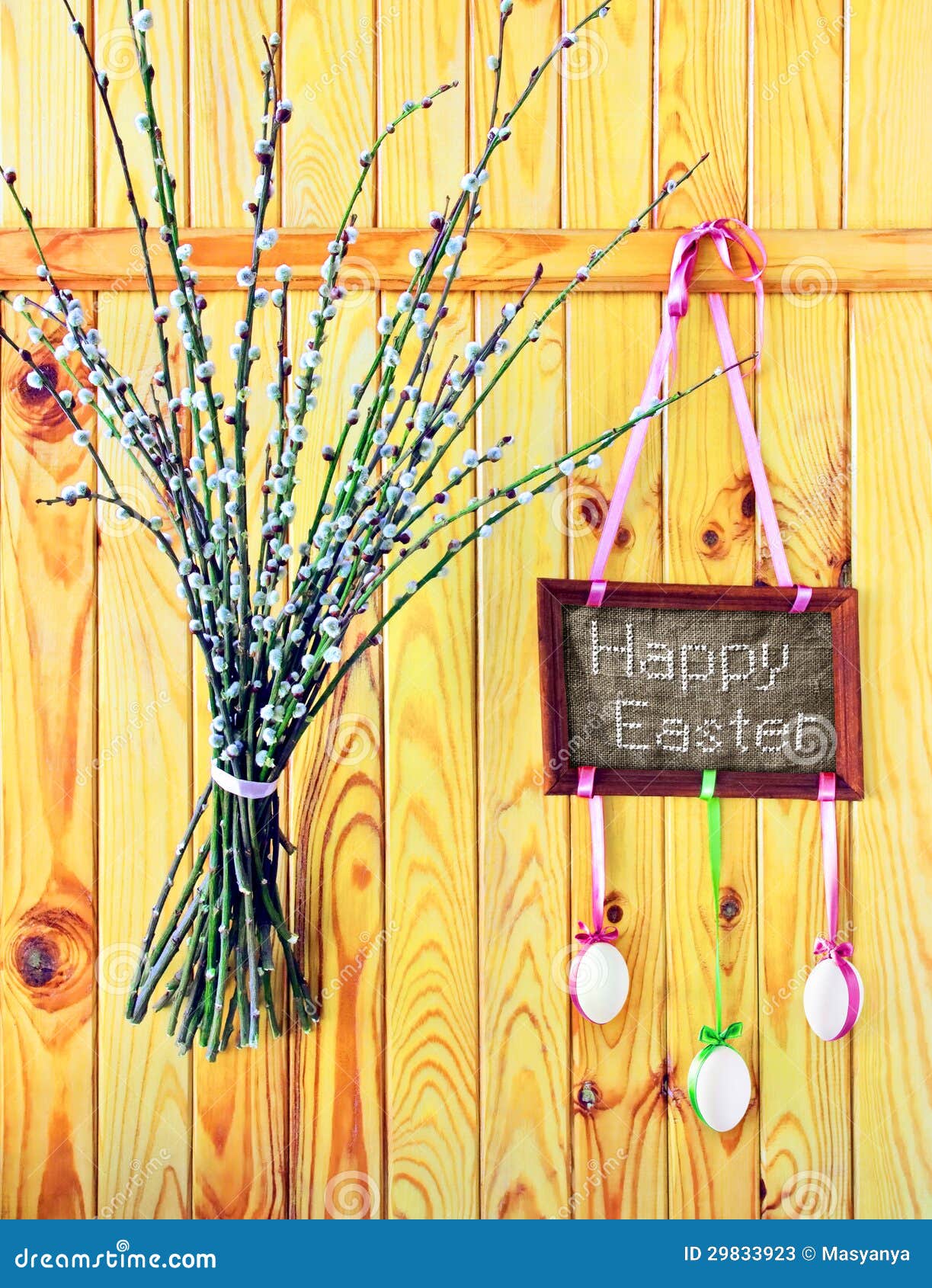Wooden fence with embroidered 'Happy Easter' greeting, eggs and willow 