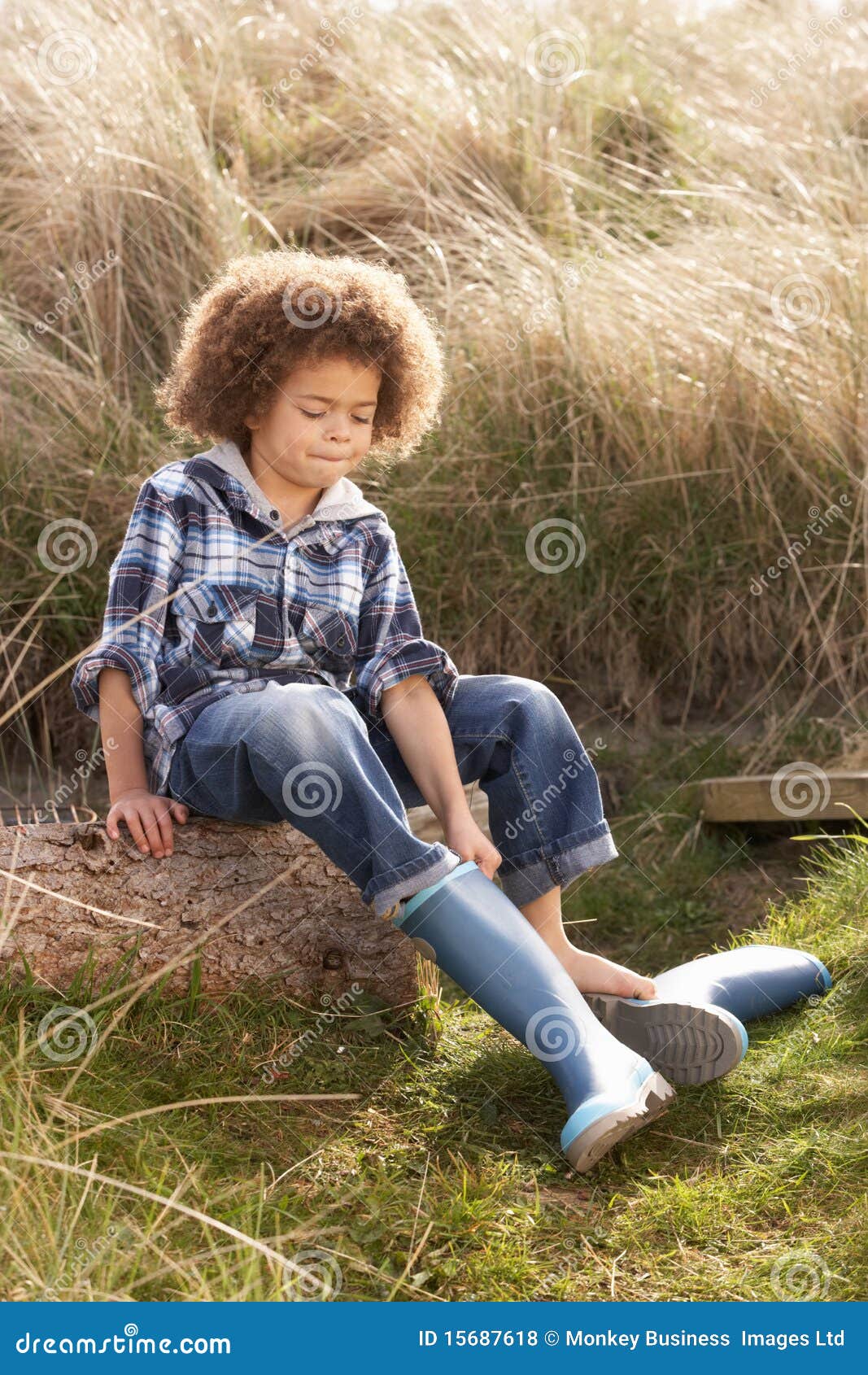 Young Boy Putting On Wellington Boots Royalty Free Stock Pho image image
