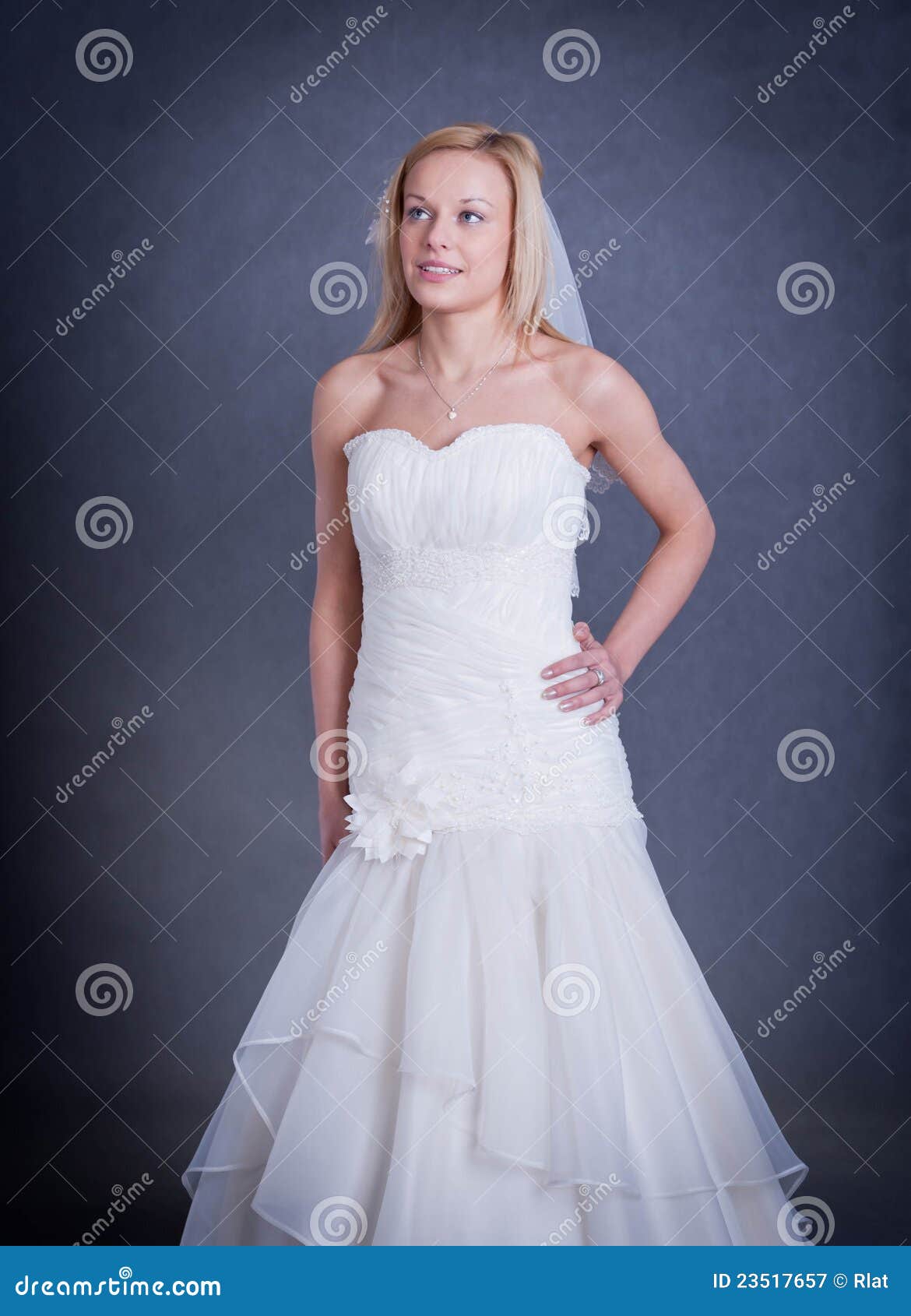 Beautiful girl in wedding dress on grey background - studio shot.
