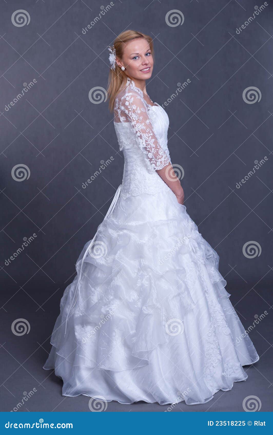 Beautiful girl in wedding dress on grey background - studio shot.