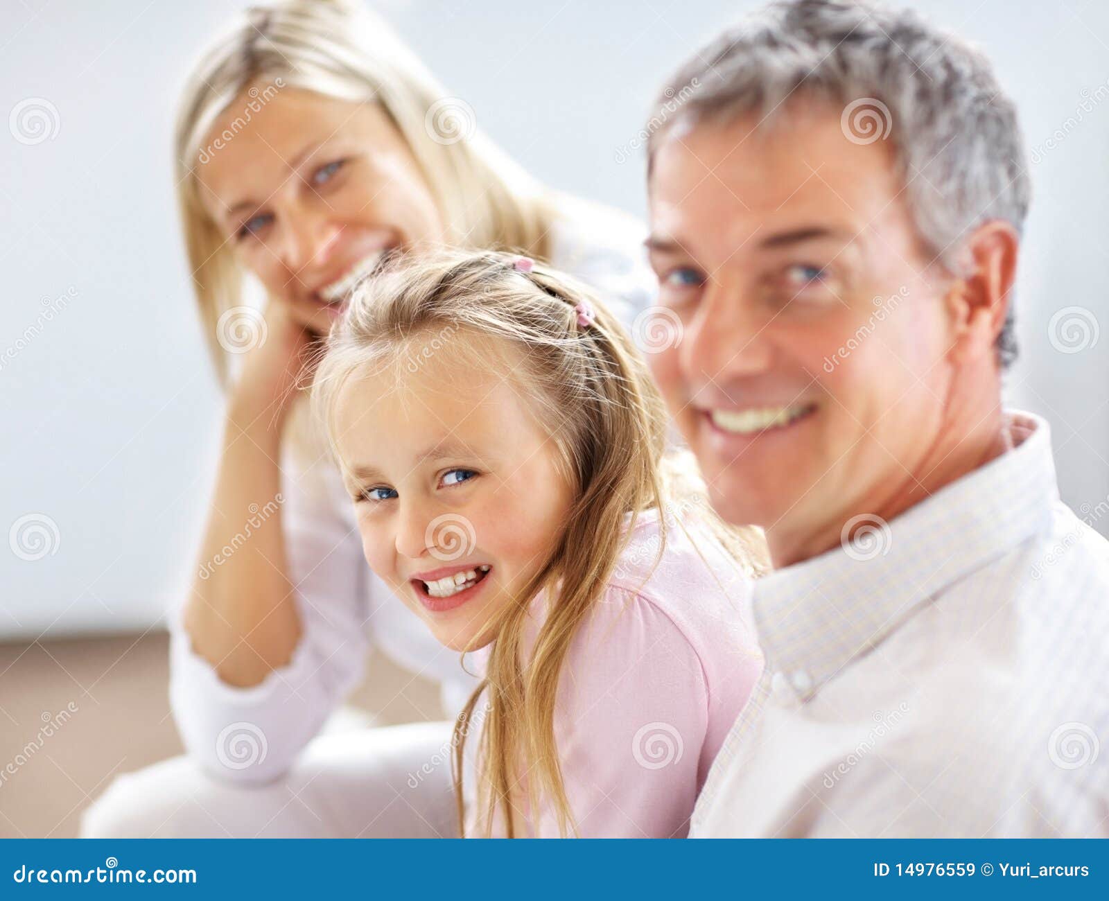 young-girl-sitting-her-parents-smiling-14976559.jpg