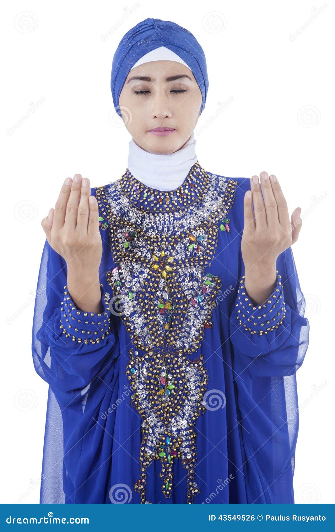 Pretty young muslim woman wearing islamic clothes and praying
