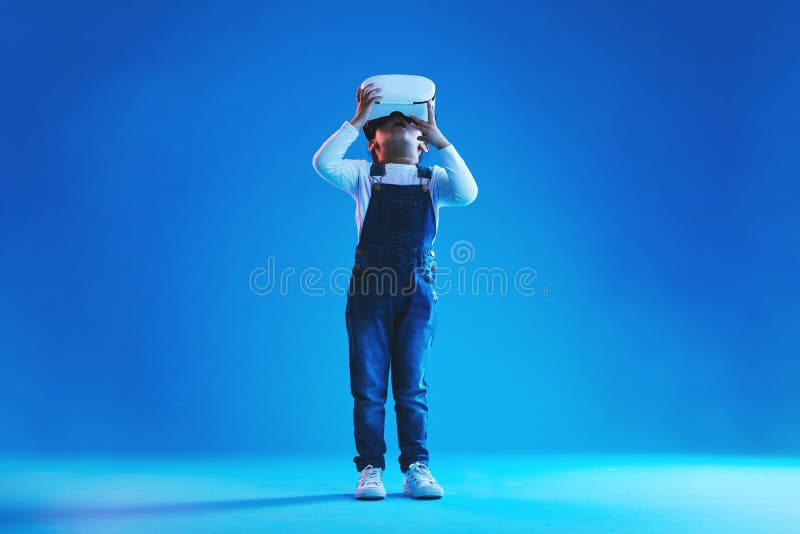 Uau, menina e criança com óculos de realidade virtual futuristas e  metaverso em um fundo de estúdio azul pessoa infantil e modelo com fone de  ouvido vr futuro e jogos on-line com