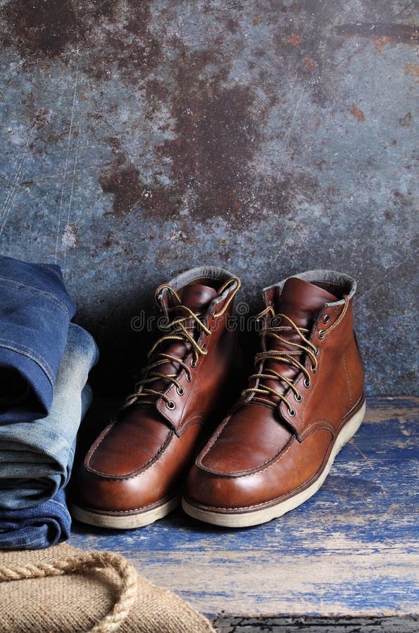 безопасные ботинки и старые джинсы на зарослях Стоковое Изображение -изображение насчитывающей цемент, обувь: 165360663