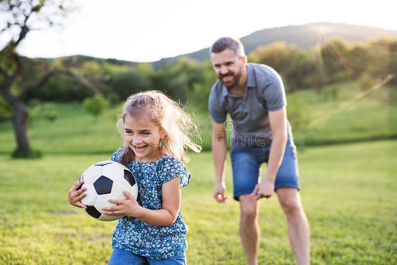 Девочка играет с папой. Футбол дочка. Папа с дочкой футбол. Папа с дочкой играет мяч. Девочка с папой играет в футбол.
