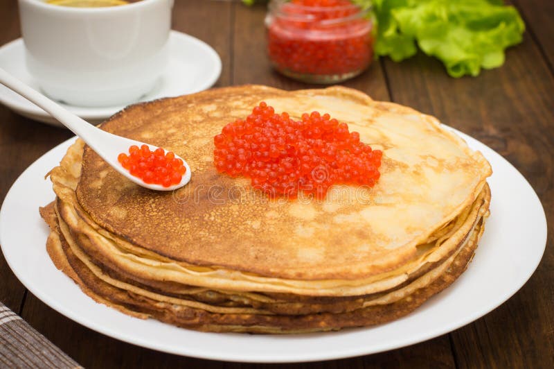 Блины с икрой на деревянном фоне