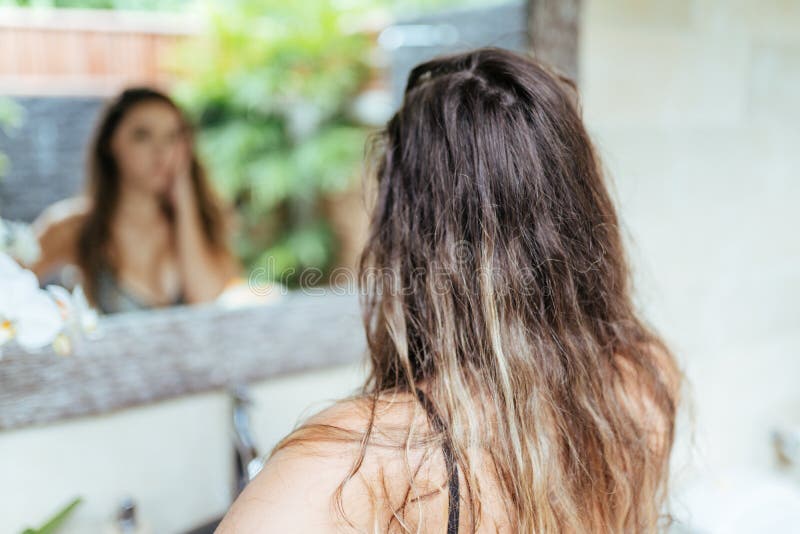 Телочка в ванной смотрит в зеркало