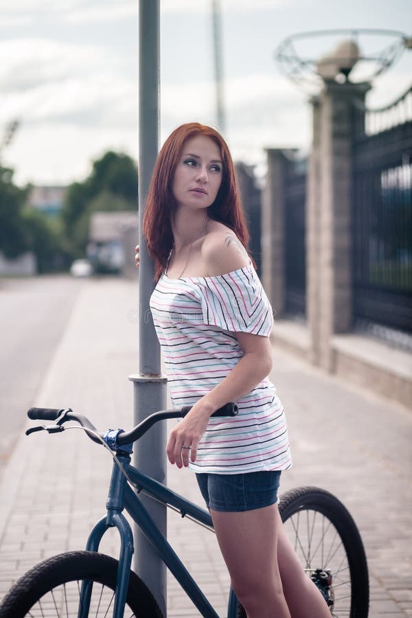 Рыжая девушка на велосипеде