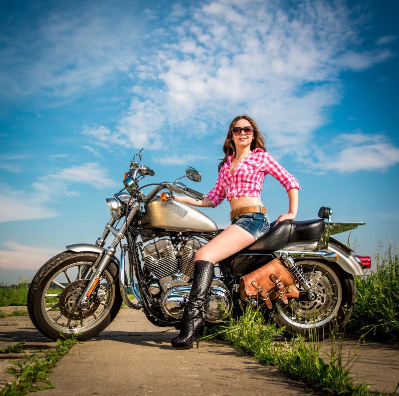 Девушка велосипедиста сидя на мотоцикле Стоковое Изображение