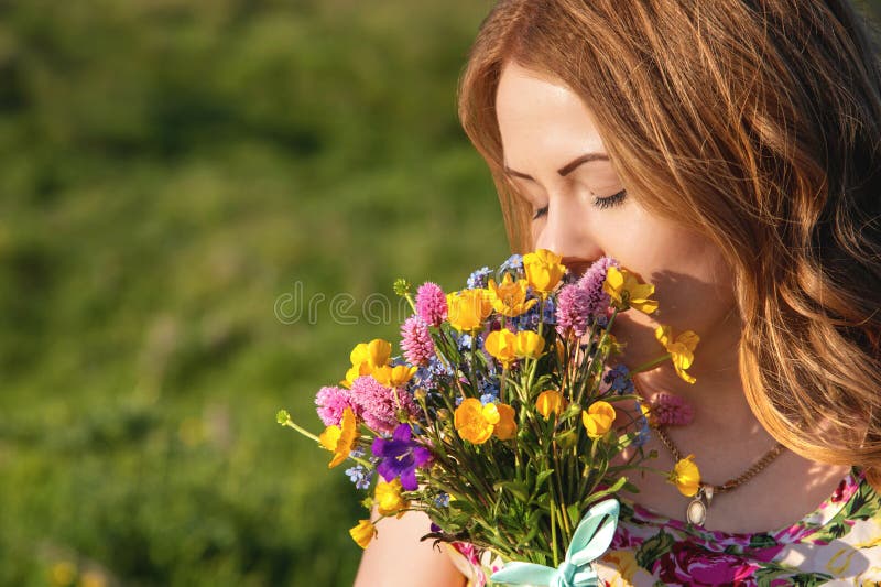 Красивая девушка нюхает цветы